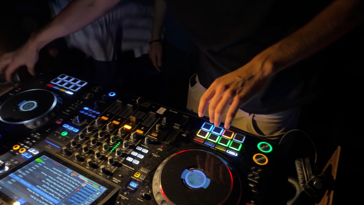 a hand riding the jog wheel, mixer pads glowing